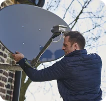 Photographie d'un technicien en train d'installer un kit satellite