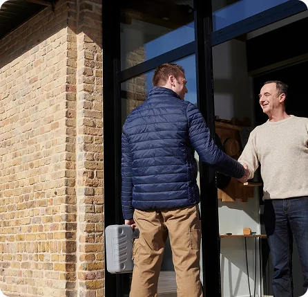 Photographie d'un client qui accueille devant chez lui un technicien